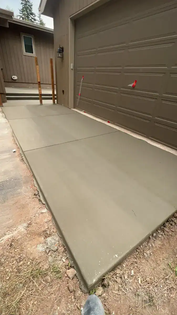 Concrete driveway extension next to garage mountain home