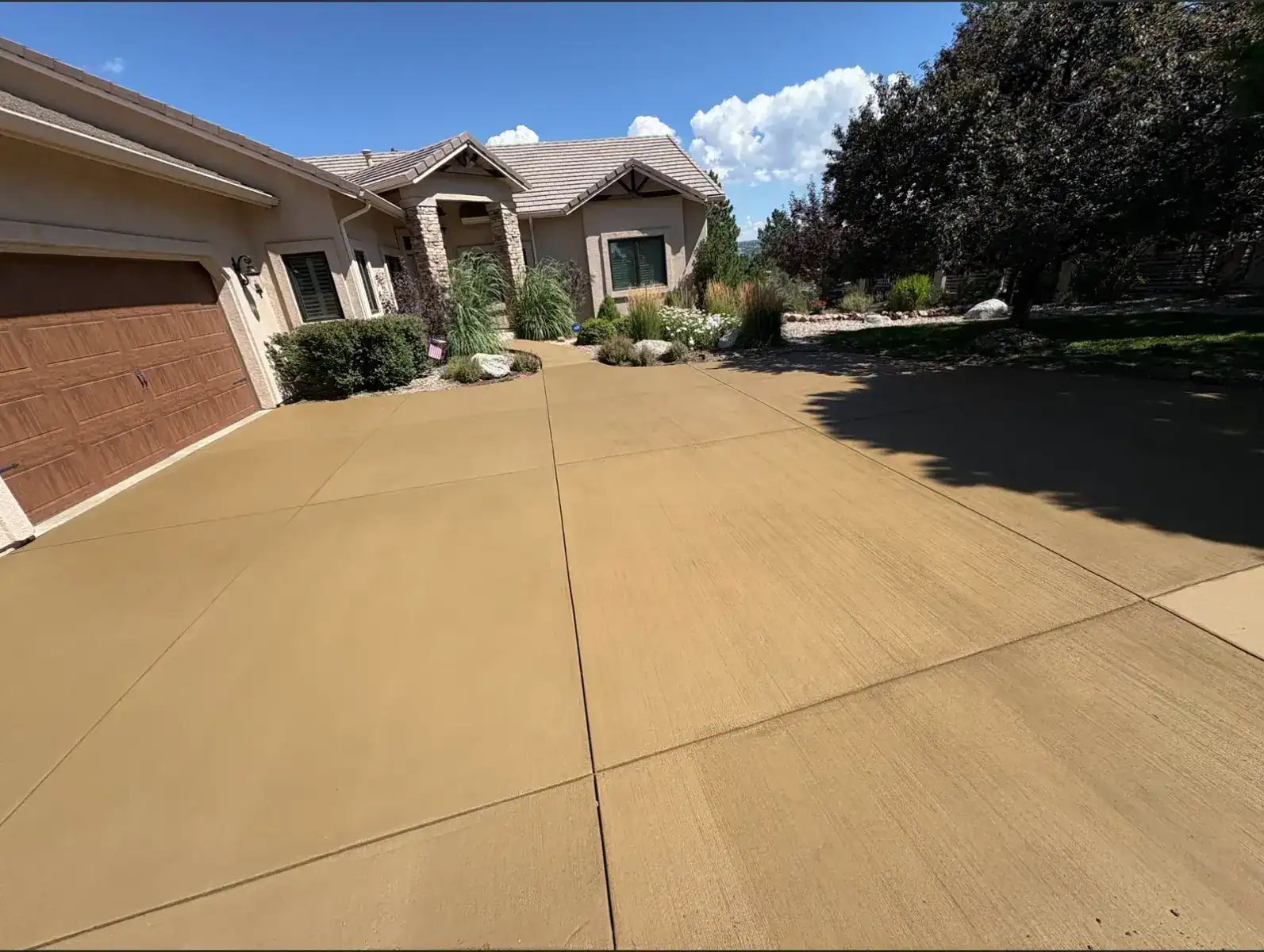Colored concrete driveway with boulder landscaping Colorado Springs