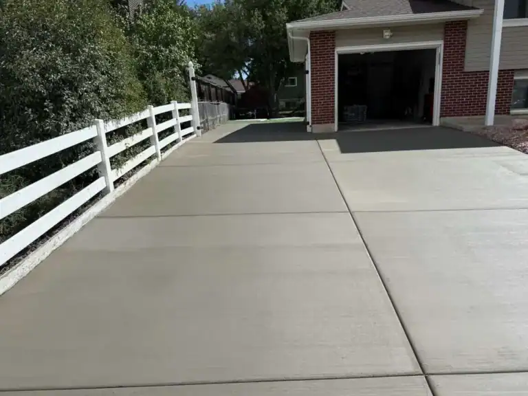 Freshly finished residential concrete driveway with broom finish leading to a garage in Colorado Springs.