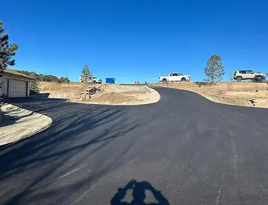 Finished asphalt driveway on an acreage property that used to be gravel